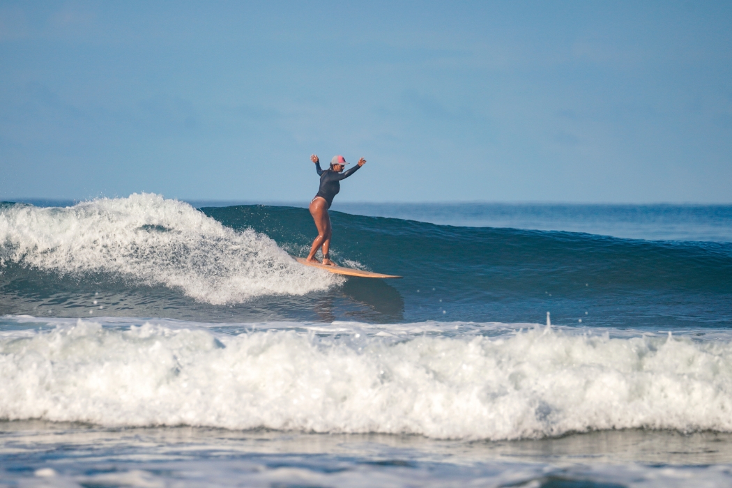 Woman on the surf board and waves at the back