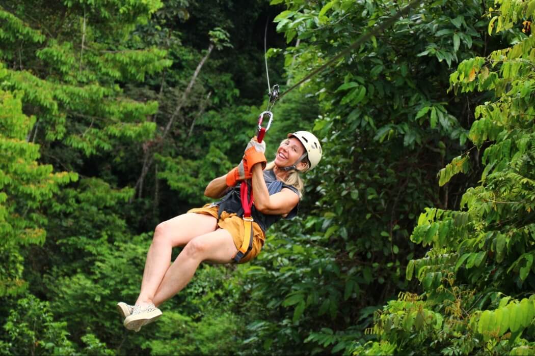 Tourist enjoying zipline canopy tour through Costa Rican rainforest