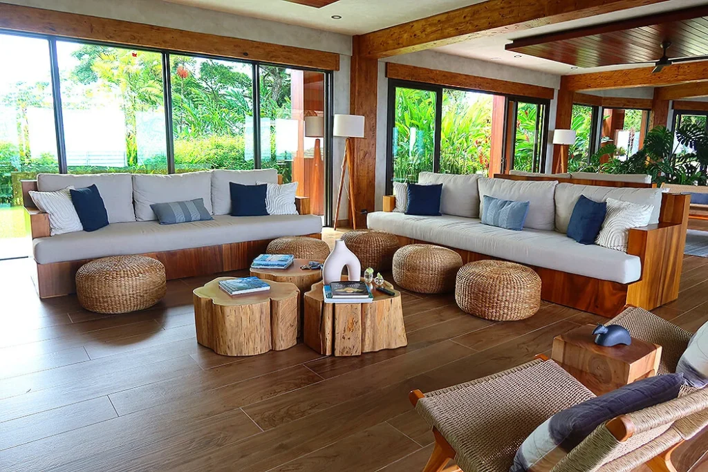 Stylish Interior of Mountain Villa Surf Resort Interior view of the villa surf resort’s hall or waiting area, featuring a blend of traditional and modern design elements with comfortable couches, decorative pillows, textured walls, and large windows that let in natural light.