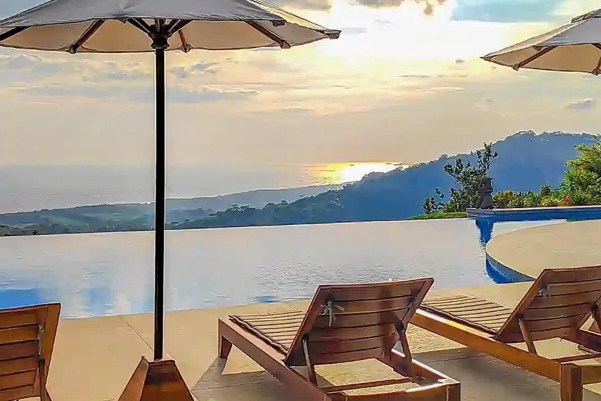Sunset View from Infinity Pool with Lounge Chairs at Lamangata Luxury Surf Resort in Costa Rica Sunset view from the infinity pool with lounge chairs at Lamangata Luxury Surf Resort in Costa Rica.