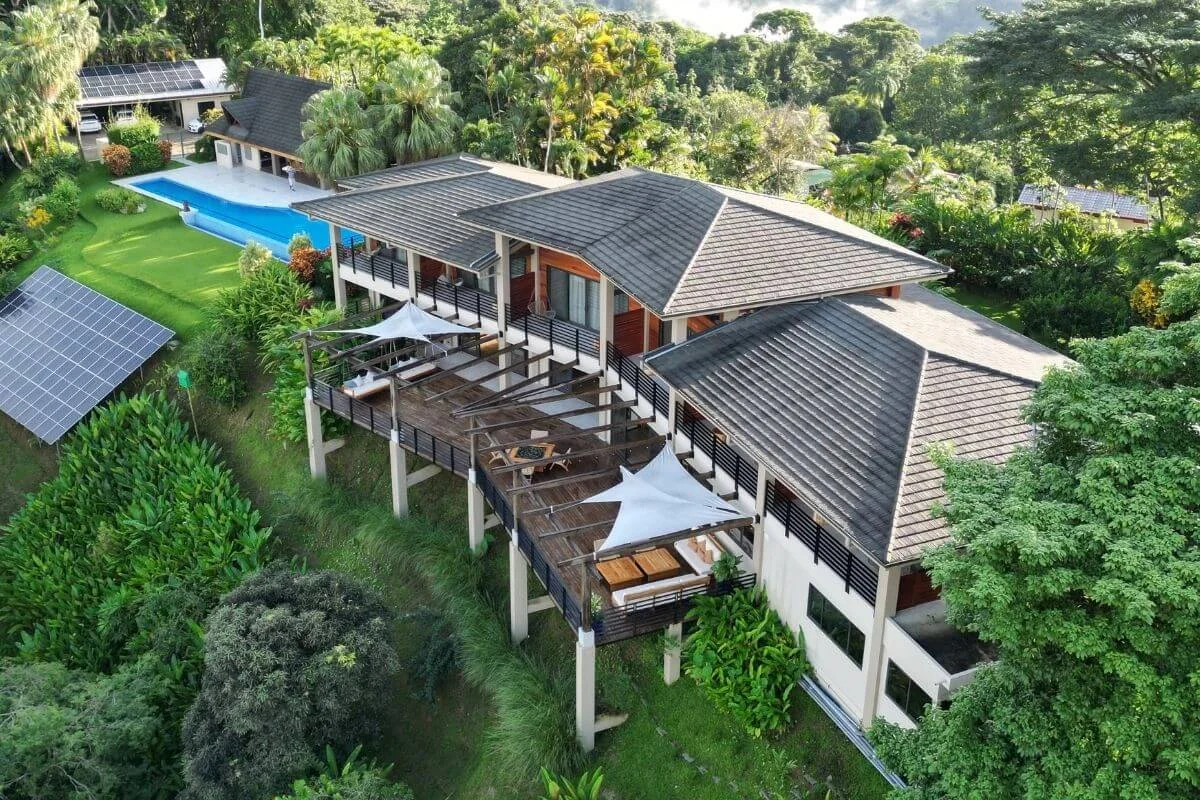 Aerial view of Lamangata Luxury Surf Resort surrounded by lush rainforest, featuring modern villas and on-site solar panels in Costa Rica.
