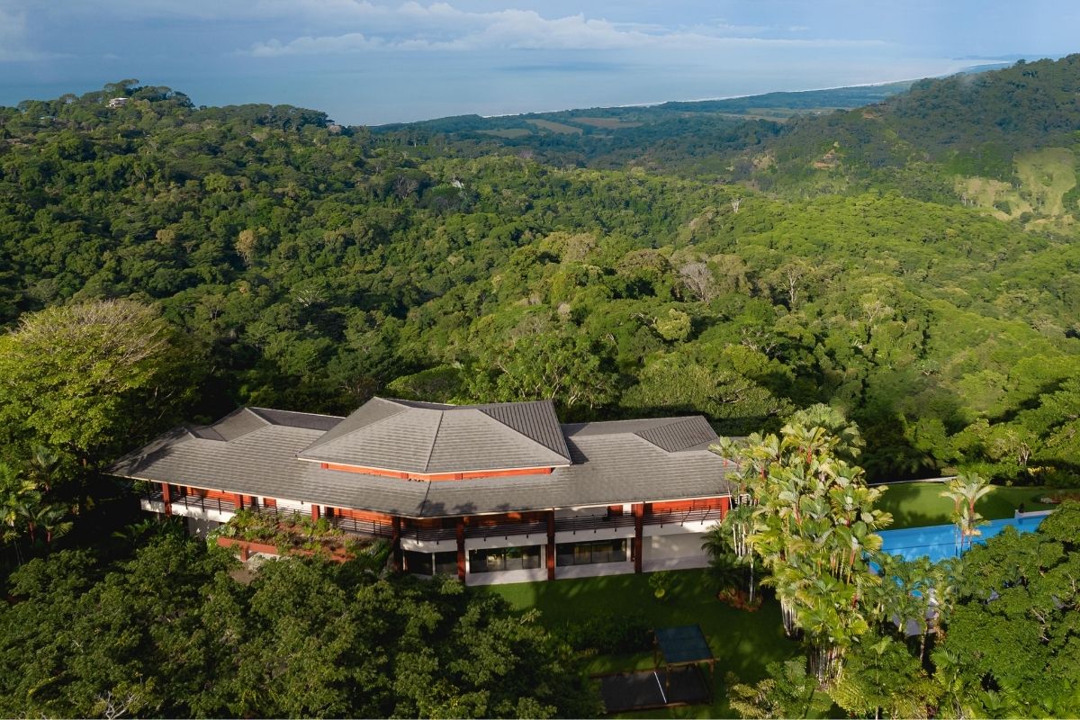 Aerial view of a luxury jungle resort surrounded by lush green rainforest with a pool, located on Costa Rica’s southern Pacific coast.