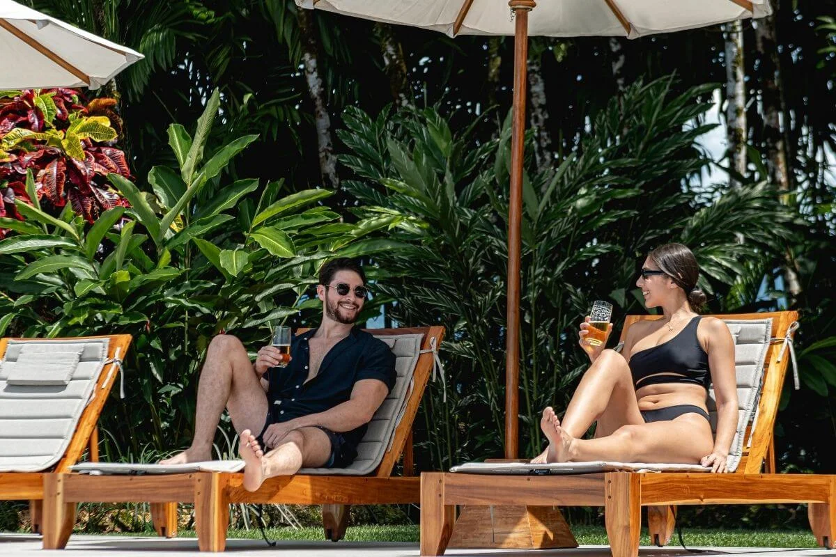 Couple relaxing on lounge chairs with drinks at Lamangata Resort