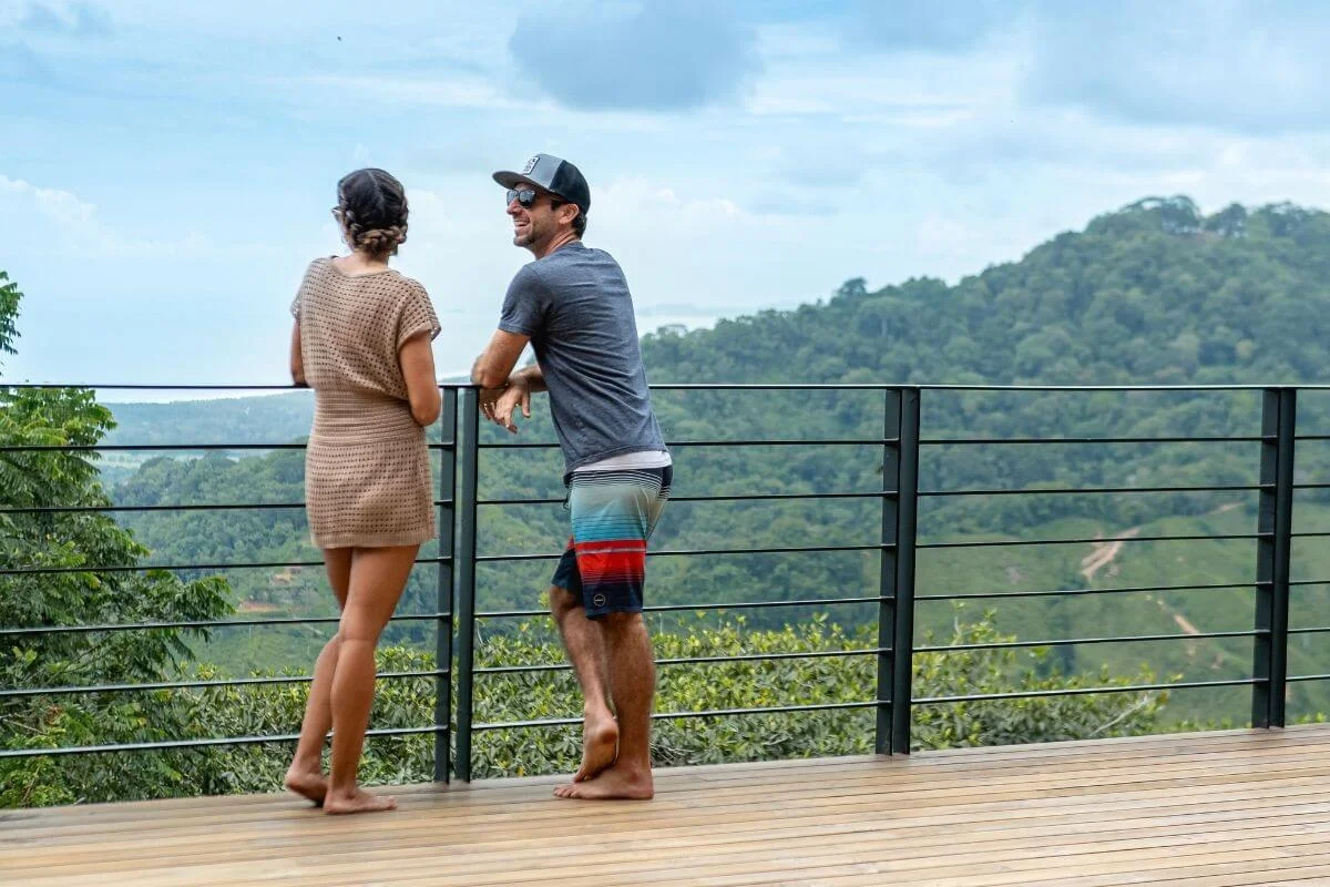 Couple enjoying jungle and ocean view from resort deck