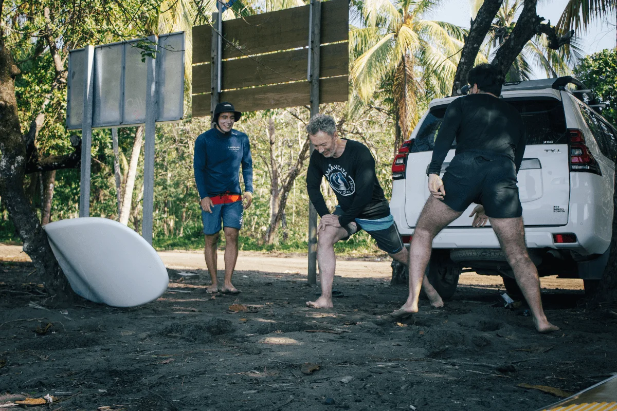 Surf coaches stretching before morning surf session