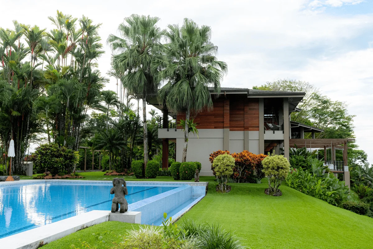 Resort pool surrounded by palm trees and tropical villa