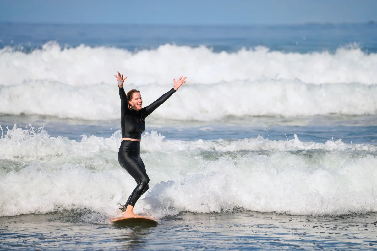 Woman celebrating catching a wave while surfing