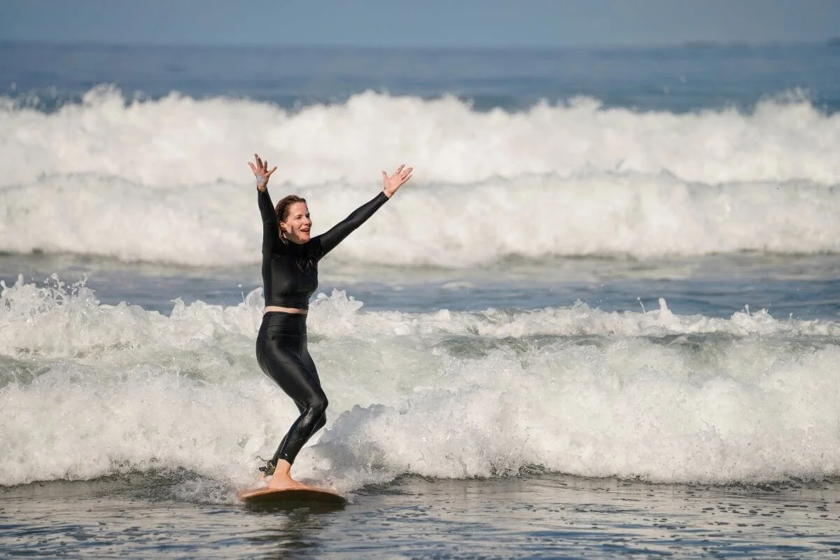 Woman celebrating catching a wave while surfing